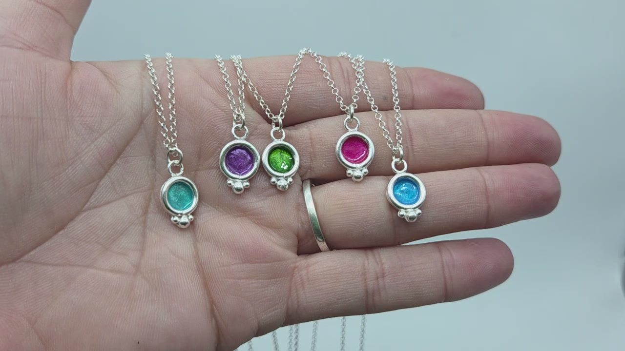 video de circo colgantes bubble realizados en plata de ley y esmaltes. se enseñan con la cadena de plata puesta y sobre una mano